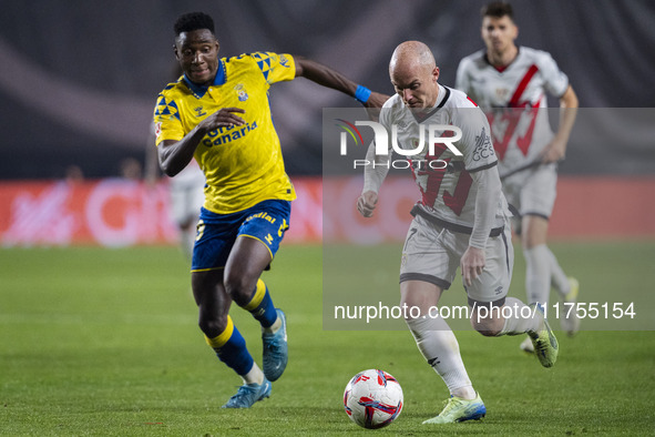 Isi Palazon of Rayo Vallecano (R) is in action against Dario Essugo of UD Las Palmas (L) during the La Liga EA Sports 2024/25 football match...