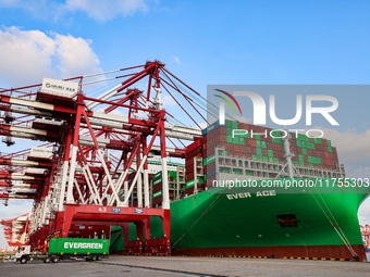 A global super-class container ship unloads containers at the Qianwan container terminal of Qingdao Port in Qingdao, China, on November 8, 2...