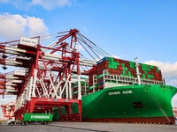 A global super-class container ship unloads containers at the Qianwan container terminal of Qingdao Port in Qingdao, China, on November 8, 2...