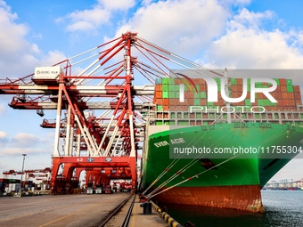 A global super-class container ship unloads containers at the Qianwan container terminal of Qingdao Port in Qingdao, China, on November 8, 2...