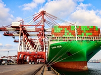 A global super-class container ship unloads containers at the Qianwan container terminal of Qingdao Port in Qingdao, China, on November 8, 2...