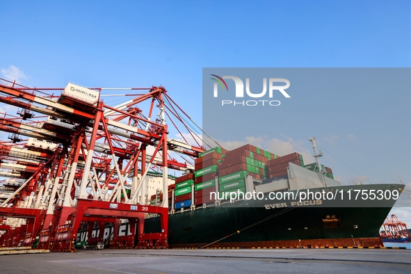 A global super-class container ship unloads containers at the Qianwan container terminal of Qingdao Port in Qingdao, China, on November 8, 2...