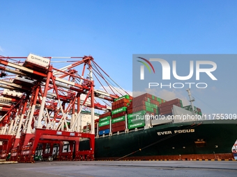 A global super-class container ship unloads containers at the Qianwan container terminal of Qingdao Port in Qingdao, China, on November 8, 2...