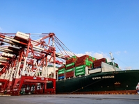 A global super-class container ship unloads containers at the Qianwan container terminal of Qingdao Port in Qingdao, China, on November 8, 2...