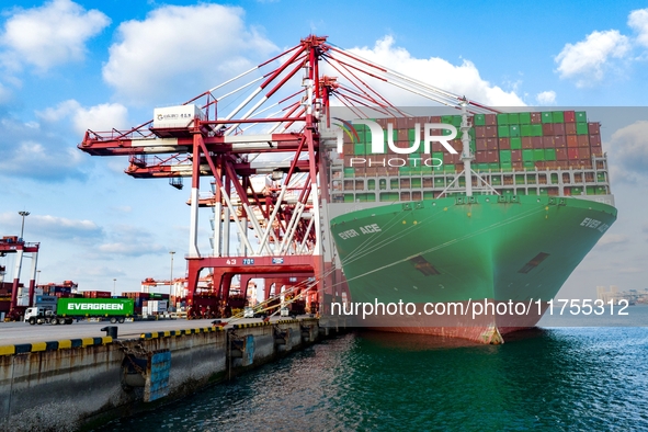 A global super-class container ship unloads containers at the Qianwan container terminal of Qingdao Port in Qingdao, China, on November 8, 2...