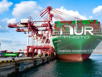 A global super-class container ship unloads containers at the Qianwan container terminal of Qingdao Port in Qingdao, China, on November 8, 2...