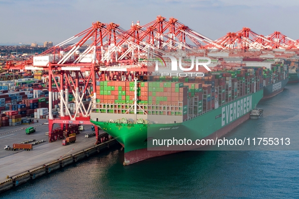 A global super-class container ship unloads containers at the Qianwan container terminal of Qingdao Port in Qingdao, China, on November 8, 2...