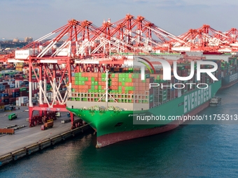 A global super-class container ship unloads containers at the Qianwan container terminal of Qingdao Port in Qingdao, China, on November 8, 2...