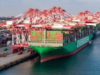 A global super-class container ship unloads containers at the Qianwan container terminal of Qingdao Port in Qingdao, China, on November 8, 2...