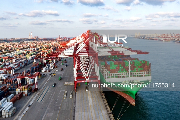 A global super-class container ship unloads containers at the Qianwan container terminal of Qingdao Port in Qingdao, China, on November 8, 2...