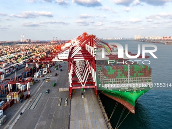 A global super-class container ship unloads containers at the Qianwan container terminal of Qingdao Port in Qingdao, China, on November 8, 2...