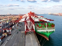 A global super-class container ship unloads containers at the Qianwan container terminal of Qingdao Port in Qingdao, China, on November 8, 2...