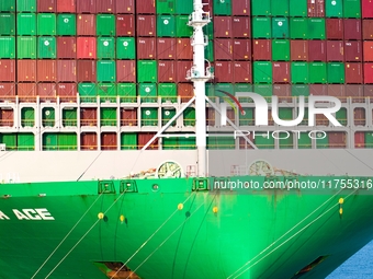 A global super-class container ship unloads containers at the Qianwan container terminal of Qingdao Port in Qingdao, China, on November 8, 2...