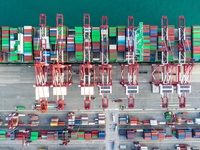 A global super-class container ship unloads containers at the Qianwan container terminal of Qingdao Port in Qingdao, China, on November 8, 2...