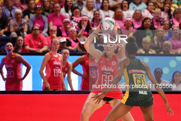 Harriet Jones of England (L) passes the ball during the Fast5 Netball World Series match between England and South Africa at the Wolfbrook A...