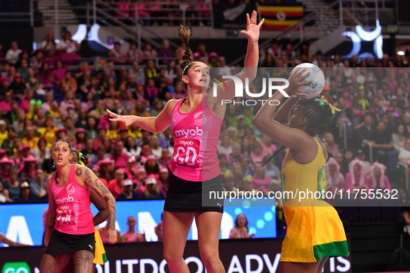 Amanda Pinkney of Jamaica shoots as Kate Burley of New Zealand attempts to catch the ball during the Fast5 Netball World Series match betwee...