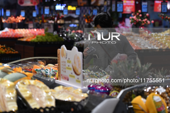 A consumer buys goods at a supermarket in Fuyang, China, on November 9, 2024. The consumer price index (CPI) rises 0.3 percent year on year...