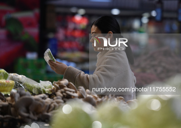 A consumer buys goods at a supermarket in Fuyang, China, on November 9, 2024. The consumer price index (CPI) rises 0.3 percent year on year...