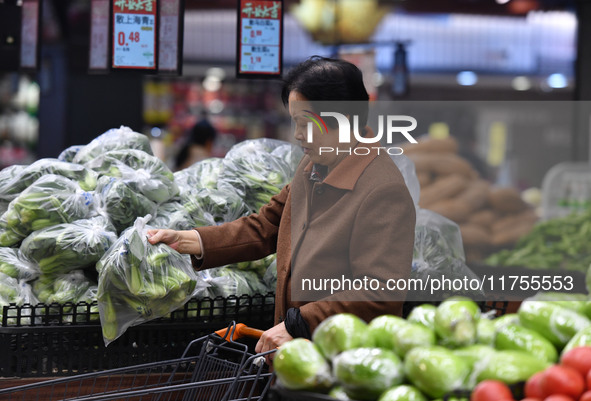 A consumer buys goods at a supermarket in Fuyang, China, on November 9, 2024. The consumer price index (CPI) rises 0.3 percent year on year...