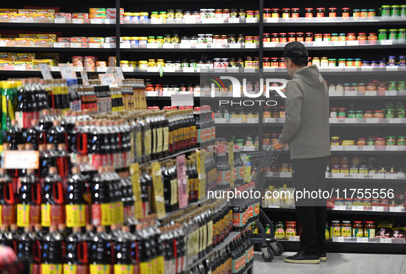 A consumer buys goods at a supermarket in Fuyang, China, on November 9, 2024. The consumer price index (CPI) rises 0.3 percent year on year...