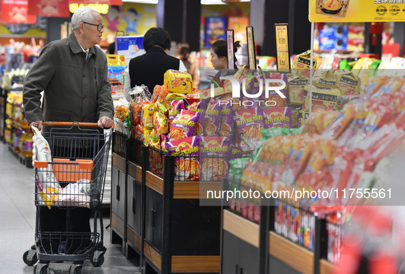 A consumer buys goods at a supermarket in Fuyang, China, on November 9, 2024. The consumer price index (CPI) rises 0.3 percent year on year...