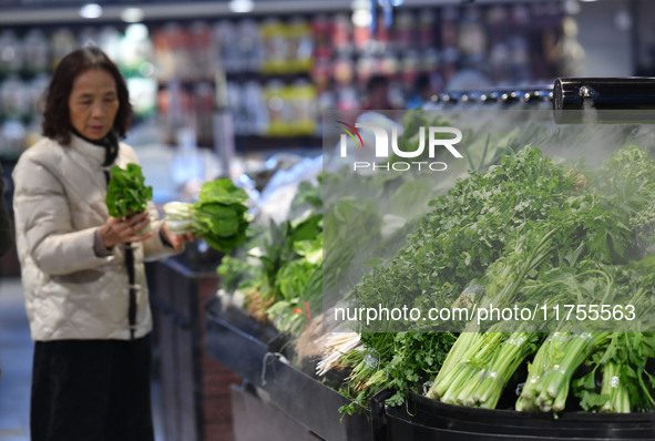 A consumer buys goods at a supermarket in Fuyang, China, on November 9, 2024. The consumer price index (CPI) rises 0.3 percent year on year...