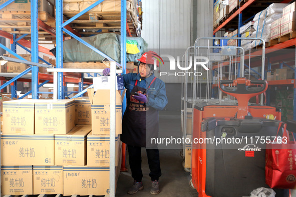 A staff member transfers goods at an e-commerce logistics warehouse in Lianyun district, Lianyungang, China, on November 9, 2024. 