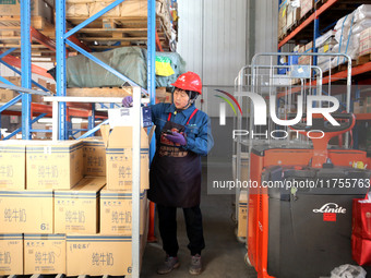 A staff member transfers goods at an e-commerce logistics warehouse in Lianyun district, Lianyungang, China, on November 9, 2024. (