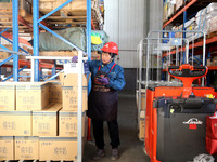 A staff member transfers goods at an e-commerce logistics warehouse in Lianyun district, Lianyungang, China, on November 9, 2024. (