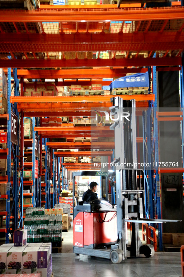 A staff member transfers goods at an e-commerce logistics warehouse in Lianyun district, Lianyungang, China, on November 9, 2024. 