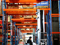 A staff member transfers goods at an e-commerce logistics warehouse in Lianyun district, Lianyungang, China, on November 9, 2024. (