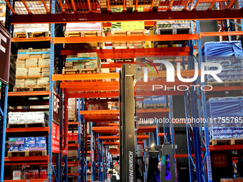 A staff member transfers goods at an e-commerce logistics warehouse in Lianyun district, Lianyungang, China, on November 9, 2024. (