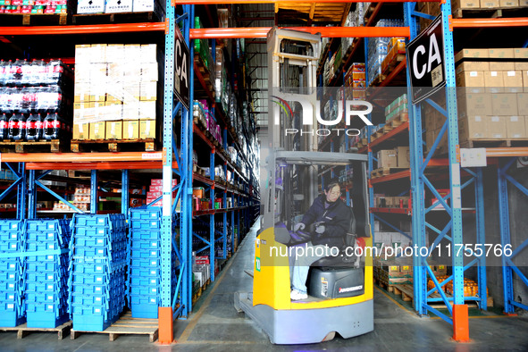 A staff member transfers goods at an e-commerce logistics warehouse in Lianyun district, Lianyungang, China, on November 9, 2024. 