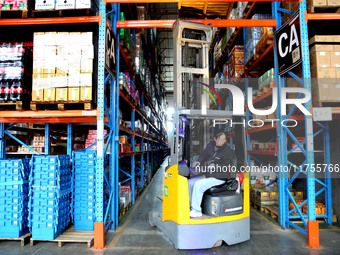 A staff member transfers goods at an e-commerce logistics warehouse in Lianyun district, Lianyungang, China, on November 9, 2024. (