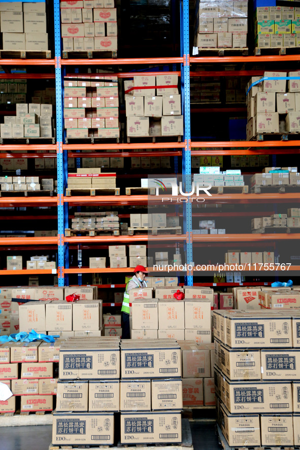 A staff member transfers goods at an e-commerce logistics warehouse in Lianyun district, Lianyungang, China, on November 9, 2024. 