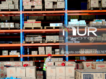 A staff member transfers goods at an e-commerce logistics warehouse in Lianyun district, Lianyungang, China, on November 9, 2024. (