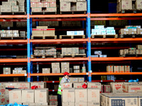 A staff member transfers goods at an e-commerce logistics warehouse in Lianyun district, Lianyungang, China, on November 9, 2024. (