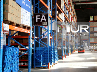 A staff member transfers goods at an e-commerce logistics warehouse in Lianyun district, Lianyungang, China, on November 9, 2024. (