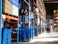 A staff member transfers goods at an e-commerce logistics warehouse in Lianyun district, Lianyungang, China, on November 9, 2024. (