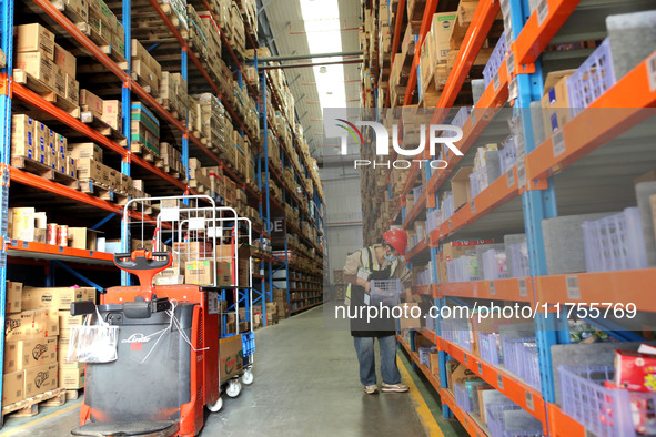 A staff member transfers goods at an e-commerce logistics warehouse in Lianyun district, Lianyungang, China, on November 9, 2024. 