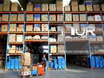 A staff member transfers goods at an e-commerce logistics warehouse in Lianyun district, Lianyungang, China, on November 9, 2024. (