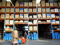 A staff member transfers goods at an e-commerce logistics warehouse in Lianyun district, Lianyungang, China, on November 9, 2024. (