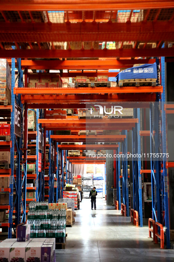 A staff member transfers goods at an e-commerce logistics warehouse in Lianyun district, Lianyungang, China, on November 9, 2024. 