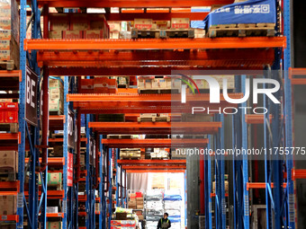 A staff member transfers goods at an e-commerce logistics warehouse in Lianyun district, Lianyungang, China, on November 9, 2024. (