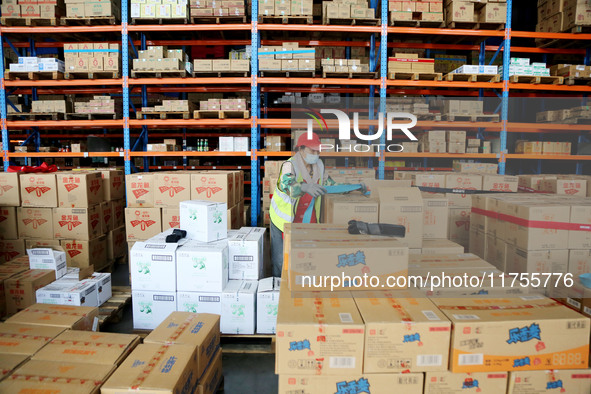 A staff member transfers goods at an e-commerce logistics warehouse in Lianyun district, Lianyungang, China, on November 9, 2024. 