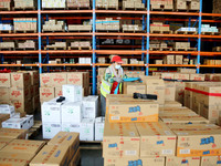 A staff member transfers goods at an e-commerce logistics warehouse in Lianyun district, Lianyungang, China, on November 9, 2024. (