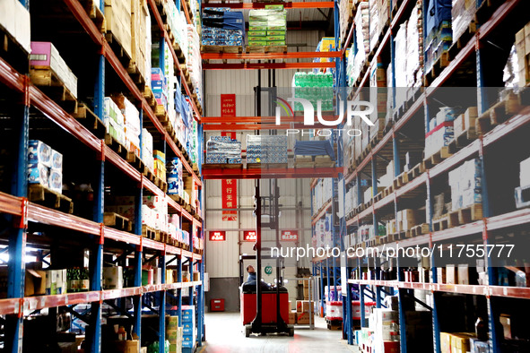 A staff member transfers goods at an e-commerce logistics warehouse in Lianyun district, Lianyungang, China, on November 9, 2024. 