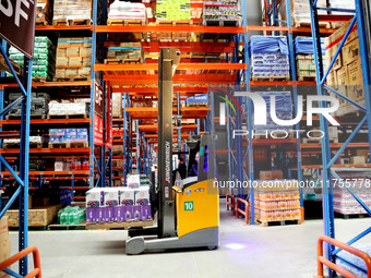 A staff member transfers goods at an e-commerce logistics warehouse in Lianyun district, Lianyungang, China, on November 9, 2024. (