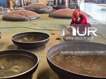 A worker works at a gas purification equipment manufacturing company in Qingzhou Economic Development Zone in Qingzhou, China, on November 9...