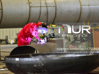 A worker works at a gas purification equipment manufacturing company in Qingzhou Economic Development Zone in Qingzhou, China, on November 9...